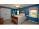 Cozy bedroom features blue walls, carpet and a wooden bed frame with matching night stand at 4455 Sirrocco Sw Ln, Lilburn, GA 30047