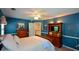 Bedroom features blue walls, carpet and a wooden bed frame with matching dresser and media center at 4455 Sirrocco Sw Ln, Lilburn, GA 30047