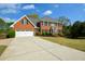 Attractive two-story brick home featuring a long driveway and a well-kept lawn at 4455 Sirrocco Sw Ln, Lilburn, GA 30047