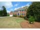 Charming two-story red brick home with manicured front lawn and lush green shrubbery at 4455 Sirrocco Sw Ln, Lilburn, GA 30047