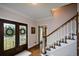 Bright entryway with hardwood floors, decorative glass front doors, and staircase to upper level at 4455 Sirrocco Sw Ln, Lilburn, GA 30047