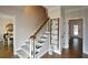 Entry hallway with wooden stairs, decorative ladder and view into dining room at 4455 Sirrocco Sw Ln, Lilburn, GA 30047