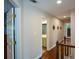 Hallway with open door to bathroom, wood floors, and diamond wall decorations at 4455 Sirrocco Sw Ln, Lilburn, GA 30047