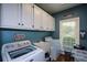 Functional laundry room with storage cabinets and modern appliances at 4455 Sirrocco Sw Ln, Lilburn, GA 30047