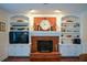 Cozy living room featuring a brick fireplace, built-in bookshelves, and neutral decor at 4455 Sirrocco Sw Ln, Lilburn, GA 30047