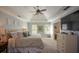 Large bedroom with tray ceilings, ceiling fan, dresser, and abundant natural light from two windows at 4455 Sirrocco Sw Ln, Lilburn, GA 30047