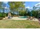 A view of a stunning pool and spa with stone accents and outdoor lounge area at 4455 Sirrocco Sw Ln, Lilburn, GA 30047