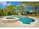 An inviting swimming pool with a connected hot tub and stone surround at 4455 Sirrocco Sw Ln, Lilburn, GA 30047