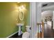 Stylish half-bathroom featuring contemporary fixtures, decorative mirror, and green accent wall at 1016 Manchester Way # 43, Roswell, GA 30075