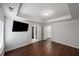 Spacious bedroom featuring hardwood floors, a tray ceiling, and multiple doors leading to other rooms at 1016 Manchester Way # 43, Roswell, GA 30075