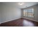 Bedroom featuring hardwood floors, a window with blinds and curtains, and natural light at 1016 Manchester Way # 43, Roswell, GA 30075