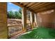 Outdoor patio featuring brick columns, a wooden railing, and artificial turf at 1016 Manchester Way # 43, Roswell, GA 30075