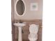 Bathroom with pedestal sink, oval mirror, tiled accent wall and tiled floors at 5449 Festival Ave, Fairburn, GA 30213