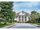 Community clubhouse features a grand entrance, pillars, and manicured landscaping at 5449 Festival Ave, Fairburn, GA 30213