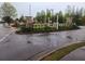 Rainy day view of the community entrance with landscaping and stone pillars at 5449 Festival Ave, Fairburn, GA 30213