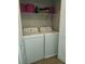 Functional laundry room with a washer, dryer, and ample storage shelving at 5449 Festival Ave, Fairburn, GA 30213