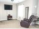 Bright main bedroom featuring a TV, mirror, recliner, and carpet flooring at 5449 Festival Ave, Fairburn, GA 30213