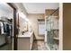 Well-lit bathroom featuring granite countertops, double sinks, and a glass enclosed shower with built-in bench at 575 W Wayside Rd, Carrollton, GA 30116