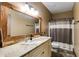 Bathroom featuring granite counters, wood framed mirror, decorative lighting, and a shower with curtain at 575 W Wayside Rd, Carrollton, GA 30116