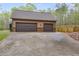 Two-car garage with dark doors, stone accents, and an expansive driveway, offering ample parking at 575 W Wayside Rd, Carrollton, GA 30116