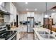 Bright kitchen features stainless steel appliances, stone backsplash and countertops, and white cabinets at 575 W Wayside Rd, Carrollton, GA 30116