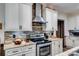 Updated kitchen featuring granite countertops, stone backsplash, stainless steel range and white cabinetry at 575 W Wayside Rd, Carrollton, GA 30116