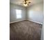 Neutrally decorated bedroom with carpet flooring and a bright window at 5990 Arbor Green Cir, Sugar Hill, GA 30518