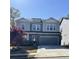 Charming two-story home with gray siding, stone accents, a two-car garage, and a well-maintained front yard at 5990 Arbor Green Cir, Sugar Hill, GA 30518