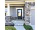 Inviting front entrance features a black door, stone accents, and a well-manicured walkway at 5990 Arbor Green Cir, Sugar Hill, GA 30518
