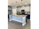 Modern kitchen features a large island with granite countertops, stylish pendant lighting, and stainless steel appliances at 5990 Arbor Green Cir, Sugar Hill, GA 30518