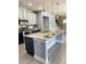 Granite island featuring a stainless steel dishwasher with overhead lighting, gray cabinets, and hardwood floor at 5990 Arbor Green Cir, Sugar Hill, GA 30518