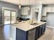 The gourmet kitchen island features granite countertops, a stainless steel sink, and modern appliances at 5990 Arbor Green Cir, Sugar Hill, GA 30518