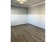 Bright room with hardwood flooring, gray accent walls, white trim, and ceiling light at 5990 Arbor Green Cir, Sugar Hill, GA 30518