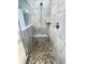 Modern tiled shower includes a built-in bench and pebble flooring at 5990 Arbor Green Cir, Sugar Hill, GA 30518