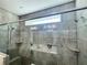 Walk-in shower features gray brick-style tile, a rainfall showerhead, and glass doors at 5990 Arbor Green Cir, Sugar Hill, GA 30518