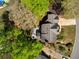Aerial view of a home with a patio surrounded by green trees in a lush, well-manicured backyard at 125 Ketton Xing, Johns Creek, GA 30097