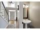 Powder room with pedestal sink and decorative mirror adjacent to the foyer and staircase at 125 Ketton Xing, Johns Creek, GA 30097