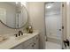 Well-lit bathroom featuring a sleek vanity with a round mirror and a shower-tub combination with tiled walls at 125 Ketton Xing, Johns Creek, GA 30097