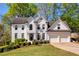 Charming two-story white brick home with attached two-car garage and a beautifully landscaped front yard at 125 Ketton Xing, Johns Creek, GA 30097