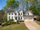 Charming two-story white brick home with attached two-car garage and a beautifully landscaped front yard at 125 Ketton Xing, Johns Creek, GA 30097