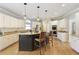 Bright kitchen boasts an island with barstools, granite countertops, and modern stainless-steel appliances at 125 Ketton Xing, Johns Creek, GA 30097