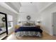 Stylish main bedroom featuring a tray ceiling, plush bedding, and natural light from the window at 125 Ketton Xing, Johns Creek, GA 30097