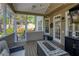Enclosed patio featuring comfortable seating, a fire table, and a view of the lush, landscaped backyard at 125 Ketton Xing, Johns Creek, GA 30097