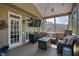 Relaxing screened porch with a TV, stylish furniture, and a cozy fire pit table for outdoor enjoyment at 125 Ketton Xing, Johns Creek, GA 30097