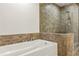 Bathroom featuring soaking tub and walk-in shower with stone accents at 270 17Th Nw St # 3604, Atlanta, GA 30363