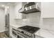 Close-up of the stainless steel range and hood, set against white herringbone backsplash and cabinets at 270 17Th Nw St # 3604, Atlanta, GA 30363
