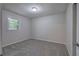 This bedroom features neutral walls, a window, and new gray carpeting at 3647 Miller St, Lithia Springs, GA 30122