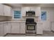 Bright kitchen features stainless steel appliances, white cabinets, gray wood-look floors, and granite countertops at 3647 Miller St, Lithia Springs, GA 30122
