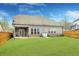 Spacious backyard with a well-maintained lawn, wooden fence, and a covered patio seating area at 403 Aristides Way, Canton, GA 30115