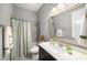 Bright bathroom featuring a framed mirror, single vanity, and a shower-tub with a curtain at 403 Aristides Way, Canton, GA 30115